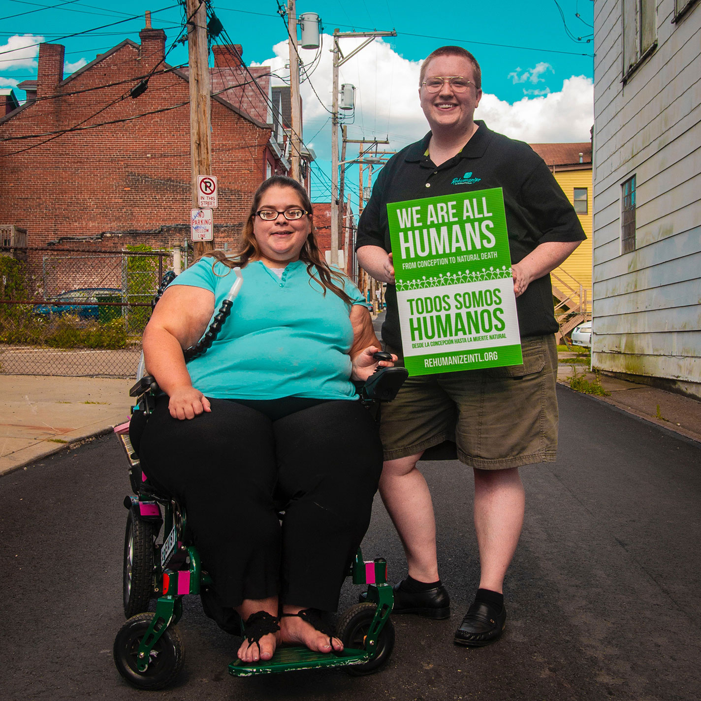 Photo of a woman and man with a sign promoting advocacy.