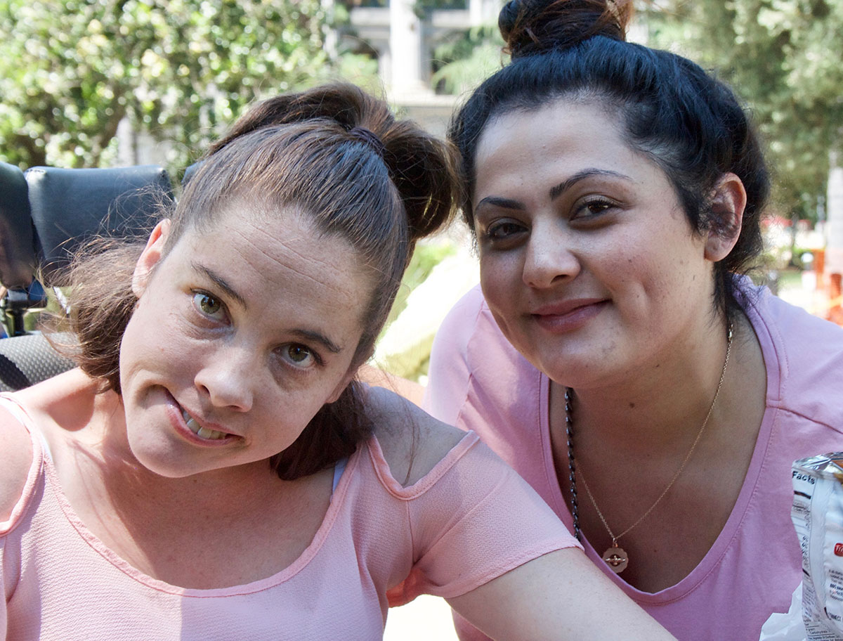 Photo of a young adult woman and her friend together outside.