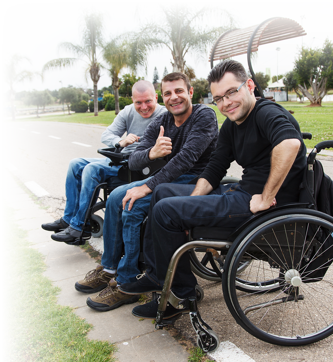 Three men together at a park in their wheelchairs. Three men together at a park in their wheelchairs.